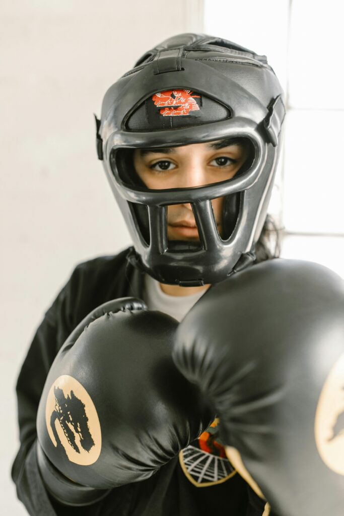 pexels photo 7045514 7045514 Close-up of a young martial artist wearing headgear and gloves, ready to spar.