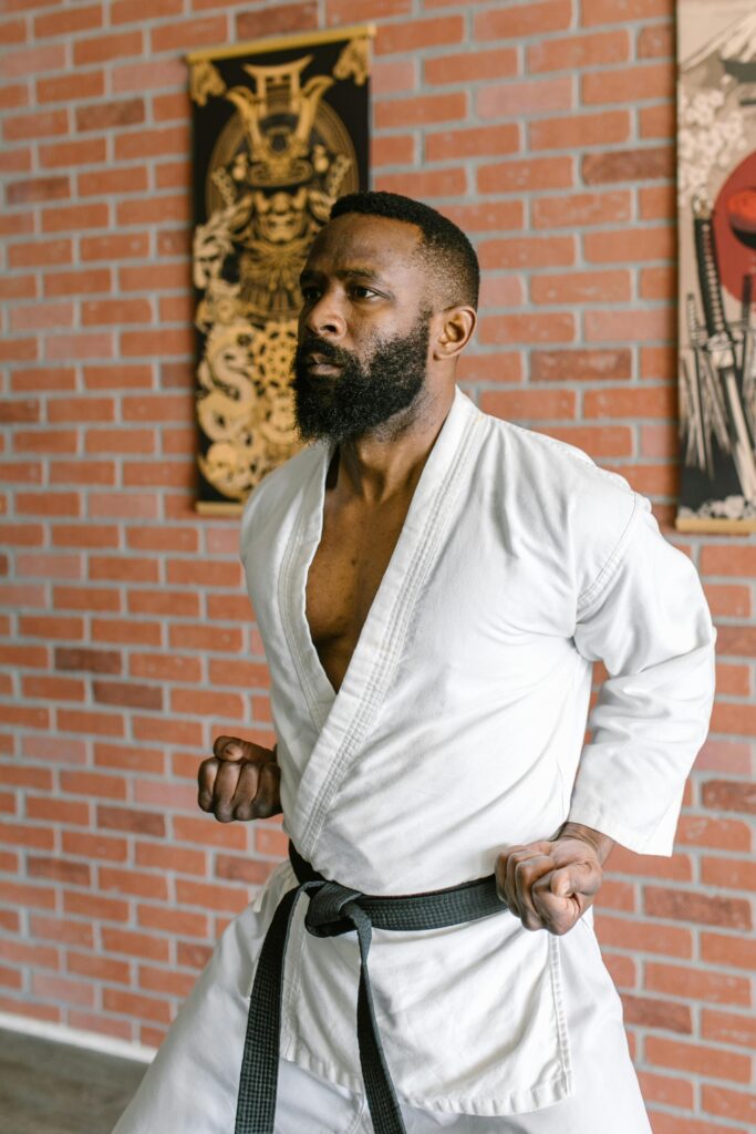 pexels photo 7045652 7045652 A focused martial artist in a white gi practices karate indoors. Brick wall background.