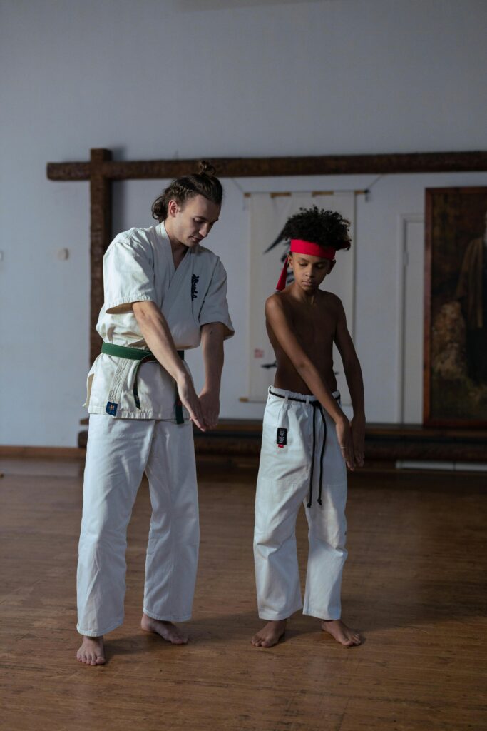 pexels photo 8041299 8041299 A martial arts trainer instructs a young boy in a dojo. Focus on discipline and skill.